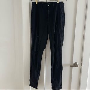 Distressed black denim jeans. Fitted.